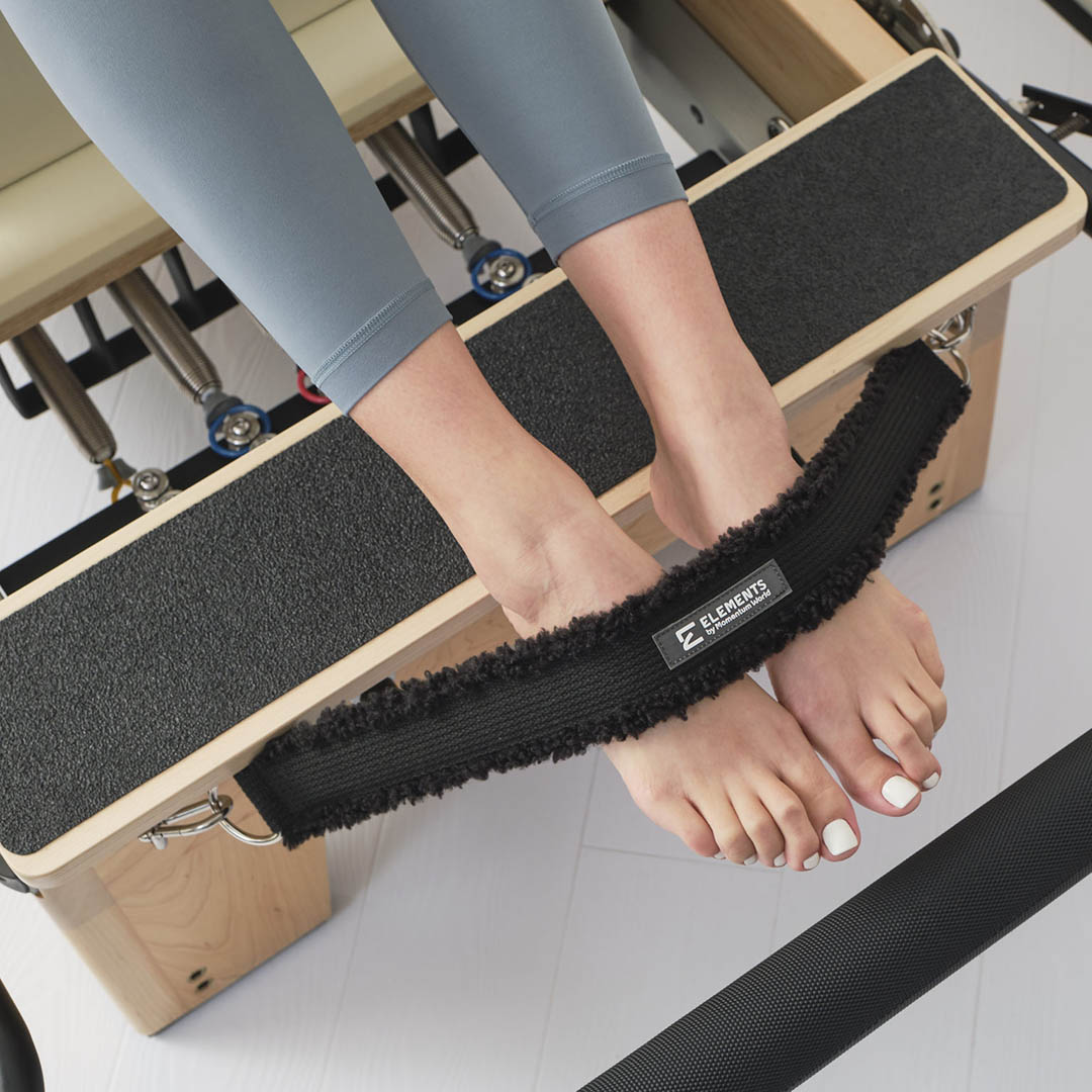 Pilates reformer: Feet in straps